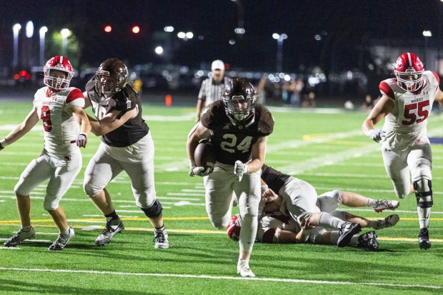 Joliet Catholic's Larry Stringham (24) sprints into the end zone tieing the game at 30 in the second overtime against Marist during a CCL/ESCC Green game in Joliet on Friday, Sept. 20, 2024. (Vincent D. Johnson / Daily Southtown)