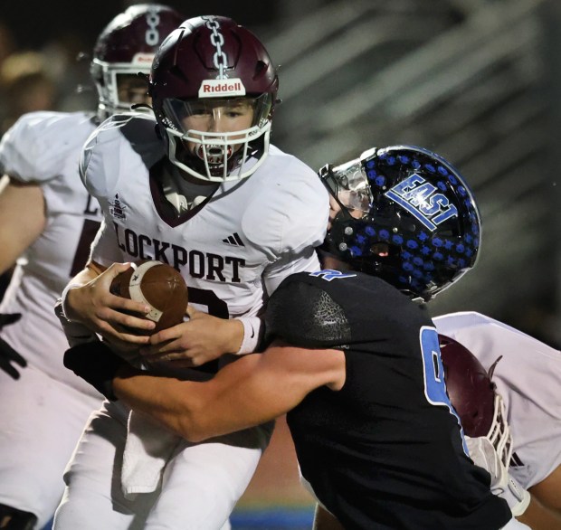 Lincoln-Way East's Caden O'rourke (right) sacks Lockport quarterback Brendan Mecher (left) during a football game in Frankfort, Il., on Friday, Oct. 11, 2024. (John Smierciak / Daily Southtown)