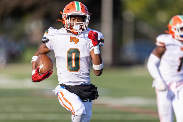 Morgan Park's Jahmare Washington (0) springs down the sidelines on a pick six against Phillips during a Chicago Public Red game at Gately Stadium in Chicago on Saturday, Oct. 12, 2024. (Vincent D. Johnson / for the Daily Southtown)