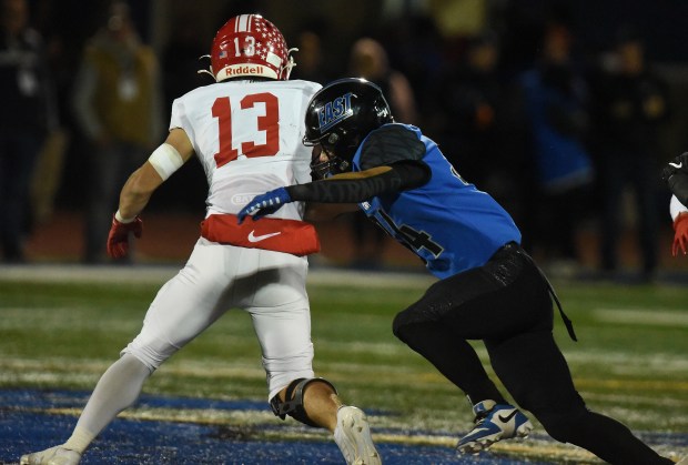 Naperville Central's Aiden Clark (13) is taken down by Lincoln-Way East's Charlie Palmer (34) during a Southwest Valley Conference game Friday, Oct. 25, 2024 in Frankfort, IL. (Steve Johnston/for the Daily Southtown)