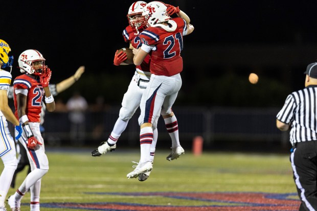 St. Rita's Andrew Elwood and St. Rita's James Kingsbury (21) jump for joy after Elwood's interception against Sandburg during a nonconference game in Chicago on Friday, Aug. 30, 2024. (Vincent D. Johnson/ Daily Southtown)