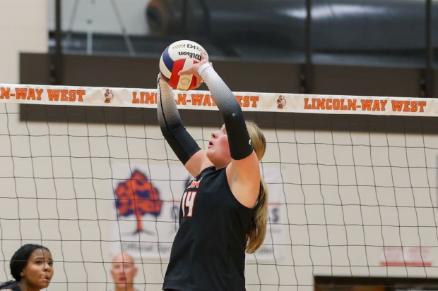 Lincoln-Way West's Claire Murphy (14) sets the ball during an SWSC match in New Lenox on Thursday, Oct. 10, 2024. (Troy Stolt / for the Daily Southtown)