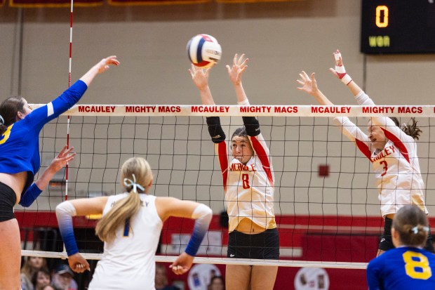 Mother McAuley's Peyton Heatherly (8) and Cayla Prohaska (3) attempt to block a hit by Lyons Township during a nonconference game in Chicago on Wednesday, Oct. 23, 2024. (Vincent D. Johnson / for the Daily Southtown)