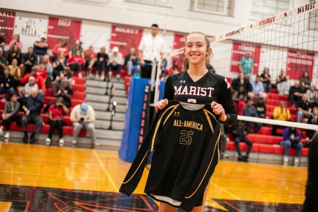 Marist's Bella Bullington (2) holds up here All-American jersey team jersey in-between sets against Marian Catholic during a nonconference game in Chicago on Tuesday, Oct. 22, 2024. (Vincent D. Johnson / for the Daily Southtown)