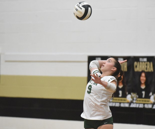 Oak Lawn's Emma McAuliffe (9) serves the ball up against Oak Forest during a South Suburban Conference volleyball match Tuesday, Oct. 8, 2024 in Oak Forest, IL. (Steve Johnston / Daily Southtown)