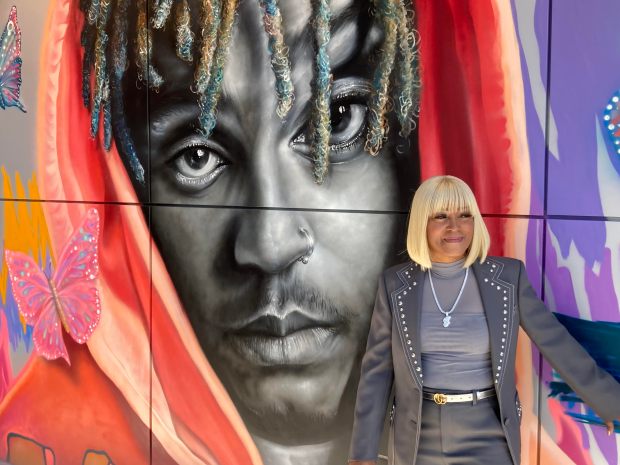 Carmella Wallace, mother of Jarad Higgins, known as rapper Juice Wrld, stands by a mural of her late son at her business, Homewood Brewing Co., Oct. 18, 2024. (Mike Nolan / Daily Southtown)