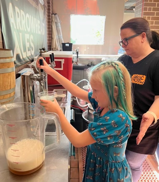 Maggie DeVries pours a glass of the beer she created with Arrowhead Ales called Keepin' it Teal. Proceeds from the beer's launch party were used to help pay Maggie's medical bills after she was diagnosed with a terminal brain cancer. (Erin DeVries)