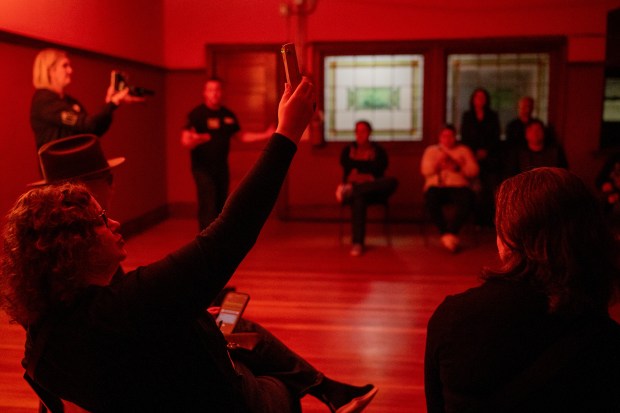 Mikki Ball holds up a K2 device used to detect electromagnetic fields to investigate for ghosts during a paranormal investigation Oct. 25, 2024, hosted by Other Side Investigations at the Pleasant Home mansion in Oak Park. (Vincent Alban/for the Chicago Tribune)