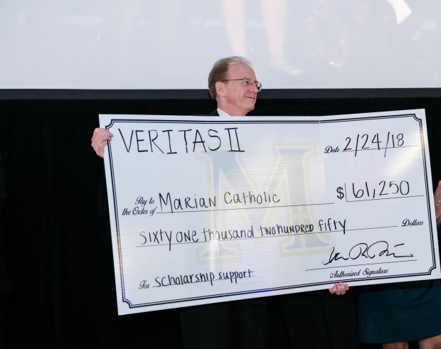 Marian Catholic President Vince Krydynski presents a check to go toward Marian Catholic scholarships at the school's 2018 scholarship gala. (Marian Catholic)