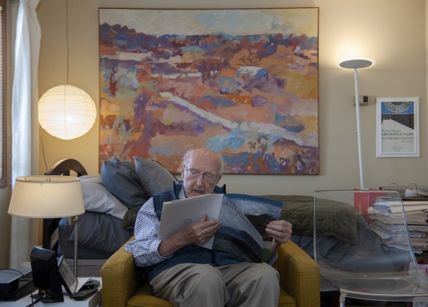 Dick Brauer, founder of the Brauer Museum of Art at Valparaiso University, looks over a VU museum publication at his home at Pines Village Retirement Communities in Valparaiso, Indiana Monday February 6, 2023. Brauer has said if the university plans to sell off millions of dollars in artwork he wants his name removed from the museum. (Andy Lavalley for the Post-Tribune)