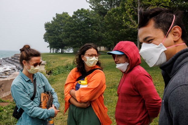 Aly Bothman, 30, from left, Miranda Mireles, 23, Max Loy, 30, and Liam Mireles, 30, wear masks at Promontory Point while smoke from Canadian wildfires passes through Chicago on June 27, 2023. According to the monitoring site IQAir, Chicago had the worst air quality out of 95 cities worldwide on that day. (Armando L. Sanchez/Chicago Tribune)