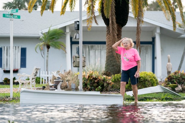 A woman walks along a flooded street in the aftermath of Hurricane Milton on Oct. 10, 2024 in Osprey, Florida. The hurricane made landfall as a Category 3 hurricane in the Siesta Key area. (Sean Rayford/Getty)