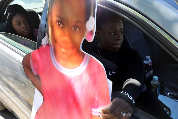 Denise Wallace, left, sister of Natalia "Natalie" Wallace, looks on as Keyosha Robinson, a friend of her father, Nathan Wallace, holds onto a large photo cutout of Natalie on July 1, 2021. (Antonio Perez/Chicago Tribune)