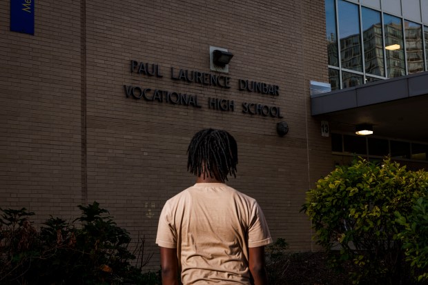 A former Dunbar Vocational Career Academy student stands near the school building on Oct. 29, 2024. (Armando L. Sanchez/Chicago Tribune)