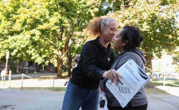 Alyssa Dons, left, principal of Cruz K-12, an Acero charter school in Chicago, greets parent Carina Parra after the final bell on Oct. 10, 2024. The public charter school network announced plans to close seven of its 15 schools starting next year, including Cruz K-12. (John J. Kim/Chicago Tribune)