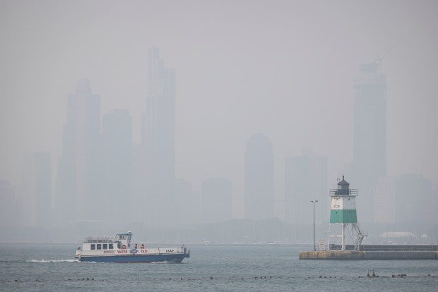 A water taxi travels offshore in Lake Michigan while wildfire haze obscures the Chicago skyline on June 27, 2023. (Brian Cassella/Chicago Tribune)