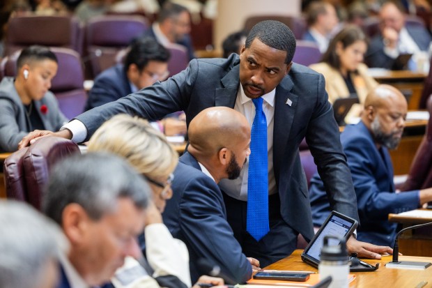 Ald. William Hall, 6th, standing, speaks with Ald. Lamont Robinson, 4th, at a City Council meeting at Chicago City Hall, Sept. 18, 2024. (Tess Crowley/Chicago Tribune)