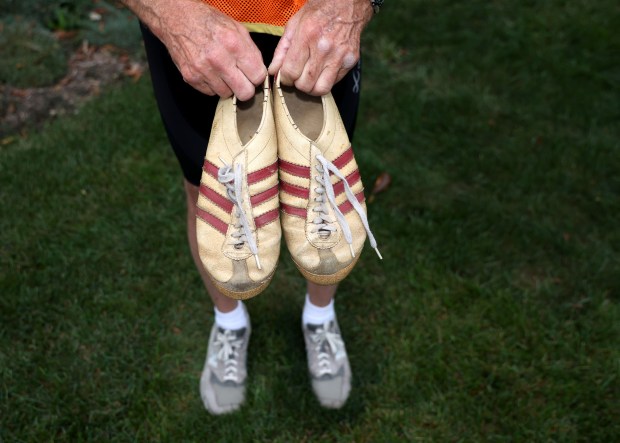 Randy Burt, 76, holds the Adidas shoes, Oct. 4, 2024, he ran in his first Chicago marathon in 1977. (Stacey Wescott/Chicago Tribune)