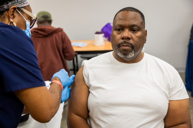 Registered Nurse Donna Feaster administers a flu shot to Thomas Brown at a 9th ward COVID-19 and Flu vaccination clinic at the Pullman Community Center on Oct. 10, 2024. (Tess Crowley/Chicago Tribune)