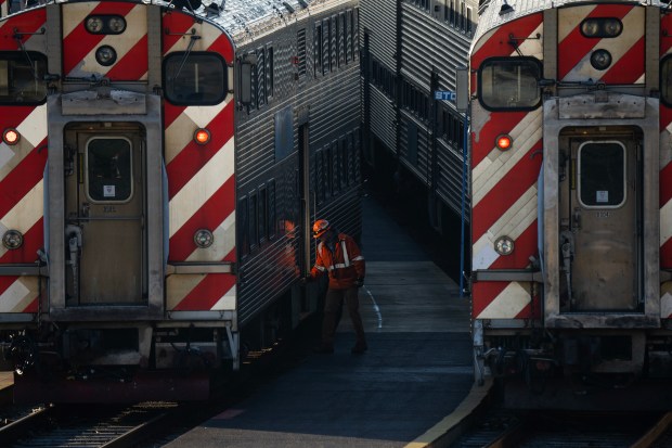 A worker walks between Metra trains in a railroad Yard at Roosevelt Road, Dec. 7, 2023. (E. Jason Wambsgans/Chicago Tribune)