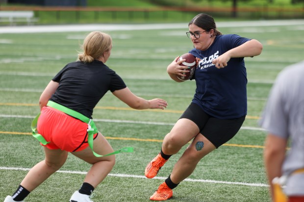 Brenna Mackey, right, does a drill while helping out at a girls flag football summer camp for her former team at Harlem High School in Machesney Park on July 9, 2024. Mackey received a scholarship to play flag football at Rockford University. (Eileen T. Meslar/Chicago Tribune)