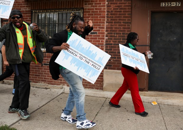 Leo Lindsay, center, dances to music as he and others walk on Homan Avenue during a march of around 75 people to the polls in the 24th ward, organized by Communities Partnering 4 Peace, a coalition of gun violence prevention groups, and UCAN, a social service agency that has served residents on the South and West sides for over 150 years, in North Lawndale on Oct. 22, 2024. Nine similar marches, all organized by the same groups took place on Chicago's South, West and North sides on Tuesday, the day after early voting began in the city's wards. Dozens proceeded about a mile from the North Lawndale Employment Network campus to the voting location at St. Agatha Catholic Parish. (Eileen T. Meslar/Chicago Tribune)