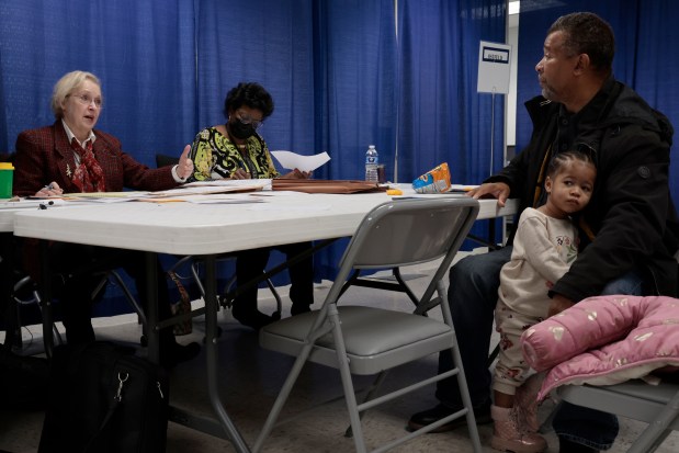 Paul McKinley, a candidate and activist, sits with his daughter, Minnie, 2, before Election Board hearings on signature challenges and other issues at the Cook County Building in Chicago, Dec. 18, 2023. (Antonio Perez/ Chicago Tribune)