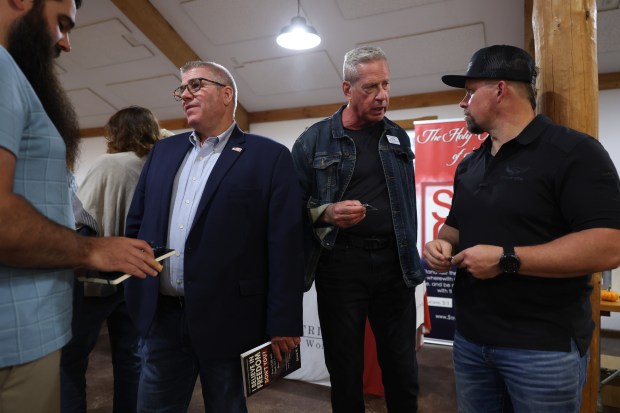 Joe McGraw, Republican candidate for the 17th Congressional District, center right, talks with colleagues and friends during an event for prospective voters at William Tree Farm, Oct. 8, 2024, in Rockton. Former state Sen. Darren Bailey stands at center left. (John J. Kim/Chicago Tribune)