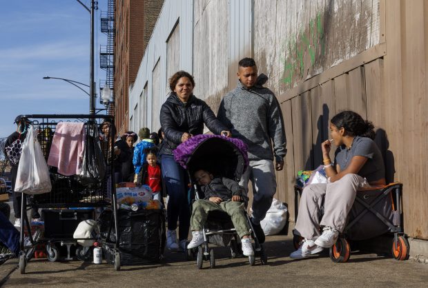 Williany Sanchez, 18, pushes her son Manuel Carvojal, 3, while walking with her husband, Danilson Carvojal, 20, outside a migrant shelter on Chicago's Lower West Side on March 11, 2024. (Armando L. Sanchez/Chicago Tribune)