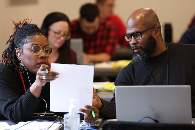 Reviewers TaQuoya McConnico, executive director for Democrats for the Illinois House, and Ronald Anderson check signatures and other information at the record review area at the Cook County's Election Operations Center in Cicero on Dec. 6, 2023. (Antonio Perez/ Chicago Tribune)