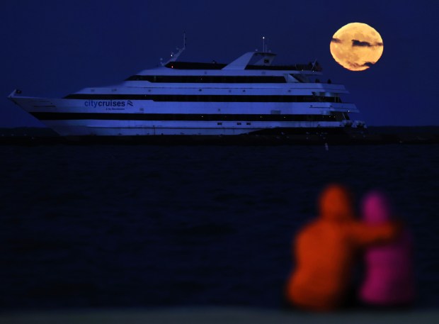 A cruise ship moves on Lake Michigan as a blue supermoon rises above Chicago on Aug. 30, 2023. (Chris Sweda/Chicago Tribune)