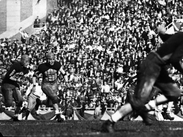 Harold "Red" Grange grabs the ball after the first kickoff of the Illinois-Michigan game in Oct. 1924, with teammate Wally McIlwain at his side. Grange began a sprint that took him over 95 yards down field for a touchdown. (Chicago Tribune historical photo)