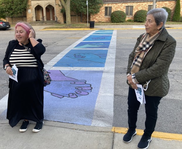 Artist Amanda Levinson, left, and Adren Shore President and CEO Dora Maya talk about the mural Levinson painted on the crosswalk. (Steve Sadin/For the Lake County News-Sun)