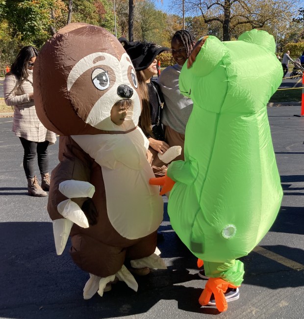 A frog and a sloth wait to enter the Trick or Treat Trail. (Steve Sadin/For the Lake County News-Sun)