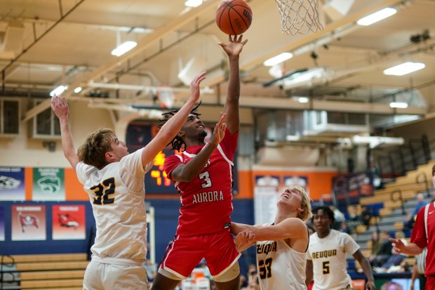 West Aurora's Jaden Edwards (3) drives to the basket against Neuqua Valley's Whitman Charboneau (32) and Andrew Hoffman (33) during a hoops for healing basketball tournament game at Oswego High School on Monday, Nov. 25, 2024. (Sean King / for The Beacon-News)