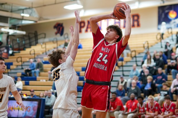 West Aurora's Gabriel Gonzales (24) shoots the ball in the wing over Neuqua Valley's Luke Johnson (20) during a hoops for healing basketball tournament game at Oswego High School on Monday, Nov. 25, 2024. (Sean King / for The Beacon-News)