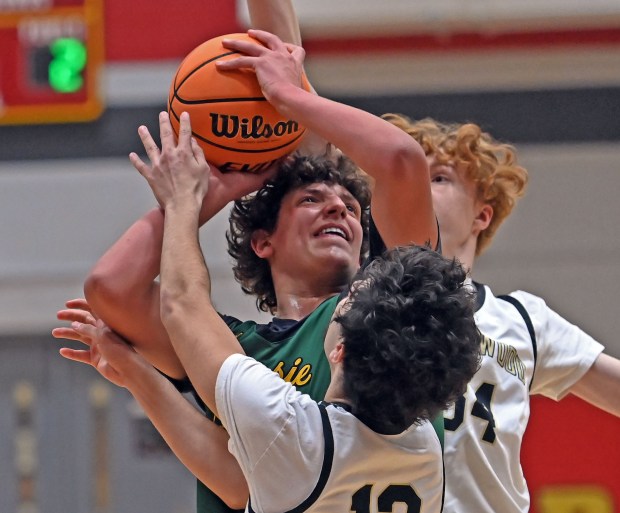 Waubonsie Valley's Kyler Payne works under the basket against Streamwood's Jessie Sanchez and Adam Hovey. Waubonsie Valley defeated Streamwood 84-29 in the Ken Peddy 2024 Windmill City Classic boys tournament, Tuesday, Nov. 26, 2024, in Batavia, Illinois. (Jon Langham/for the Beacon-News)