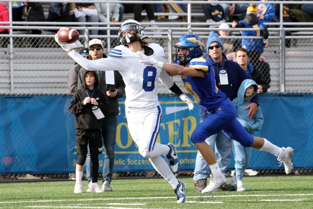 Geneva's Finnegan Weppner (8), getting around Lake Forest's Joey Schnack (blue) as he gets a hand on the pass but is unable to bring it in, during the Class 6A state quarterfinal, on Saturday, Nov. 16, 2024, in Lake Forest. (Mark Ukena/for the Pioneer Press)