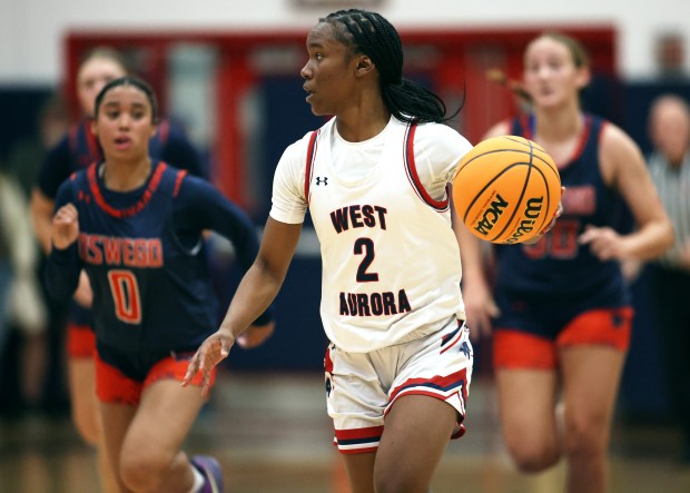 West Aurora's Syncere Williams (2)pulls away on a fast break in the third quarter from Oswego defenders Alexis Fomby (0) and Peyton Johnson (30) during the a West Aurora Thanksgiving Tournament game Monday, Nov. 25, 2024 in Aurora. (H. Rick Bamman / The Beacon-News)