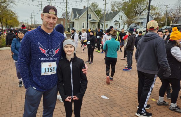 Paul Gehrmann of Aurora and his daughter Holly, 9, ran together during the fourth annual Tom-A-Hawk Turkey Trot 5K race Saturday morning in downtown Aurora. (David Sharos / For The Beacon-News)