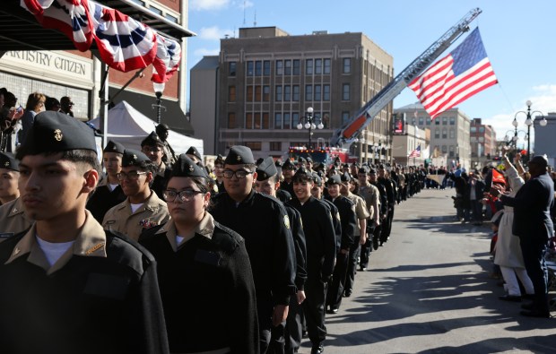 Members of the West Aurora High School ROTC program march along Downer Place during the Aurora Veterans Day Parade on Monday, Oct. 11, 2024 in Aurora. (H. Rick Bamman / for the Beacon-News)