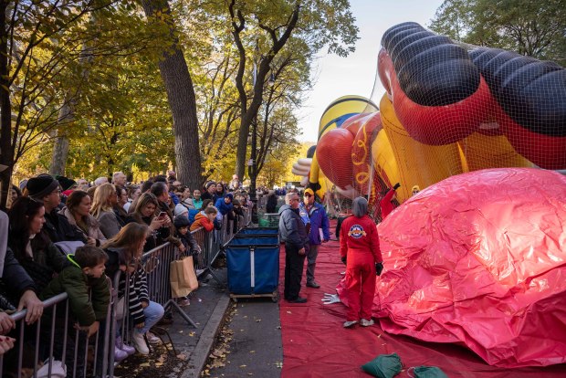 People watch floats being inflated in preparation for the Macy's Thanksgiving Day Parade, Wednesday, Nov. 27, 2024, in New York. (AP Photo/Yuki Iwamura)