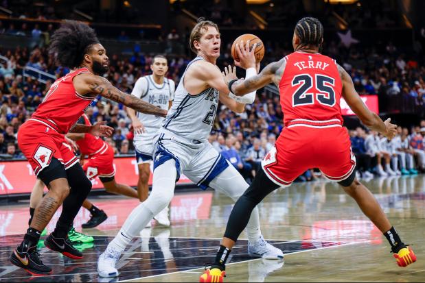 Orlando Magic center Moritz Wagner, middle, is defended by Chicago Bulls guard Coby White, left, and teammate forward Dalen Terry, right, during the first half of an NBA basketball game, Wednesday, Nov. 27, 2024, in Orlando, Fla. (AP Photo/Kevin Kolczynski)