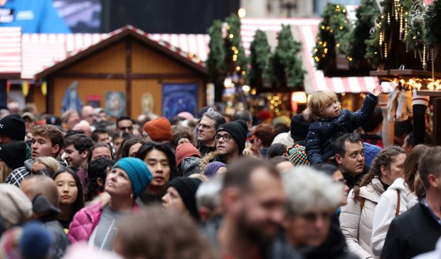 Joseph Mackey carries his daughter Margaret, 2, on his shoulders as they navigate the Christkindlmarket at Daley Plaza on Dec. 2, 2023, in Chicago. (John J. Kim/Chicago Tribune)