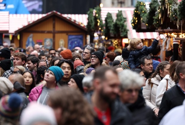 Joseph Mackey carries his daughter Margaret, 2, on his shoulders as they navigate the Christkindlmarket at Daley Plaza on Dec. 2, 2023, in Chicago. (John J. Kim/Chicago Tribune)