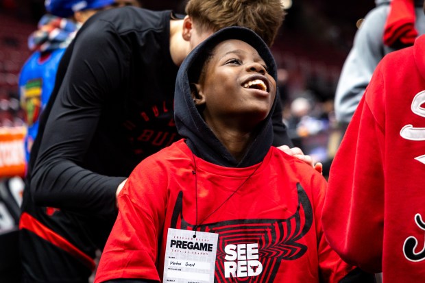 Chicago Bulls forward Matas Buzelis (14), back, signs Jakorri Waddell's, 12, center, shirt before a game against the Minnesota Timberwolves at the United Center on Nov. 7, 2024. (Tess Crowley/Chicago Tribune)