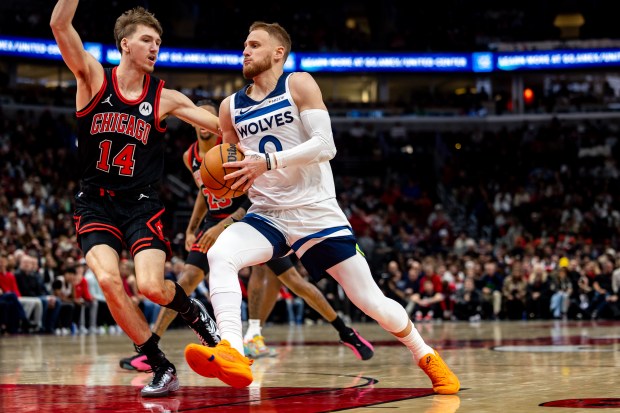 Chicago Bulls forward Matas Buzelis (14) defends Minnesota Timberwolves guard Donte DiVincenzo (0) as he runs down the court during the first quarter at the United Center on Nov. 7, 2024. (Tess Crowley/Chicago Tribune)