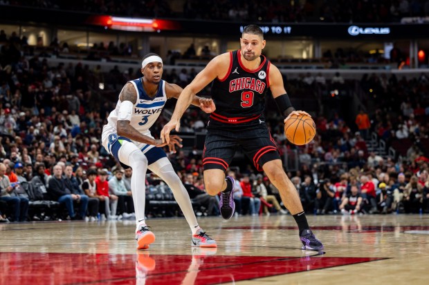 Bulls center Nikola Vucevic drives past Timberwolves forward Jaden McDaniels on Nov. 7, 2024, at the United Center. (Tess Crowley/Chicago Tribune)