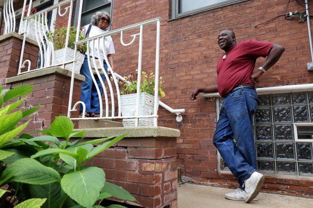 Claire Addams-Hoffman, left, and Eneal Lee share a moment in front of Addams-Hoffman's residence at the Chatham Park Village Cooperative in Chicago on Aug. 17, 2023. Among the complaints about the conditions at the cooperative is the cracked and crumbling brick structure outside Addams-Hoffman's residence. (Chris Sweda/Chicago Tribune)