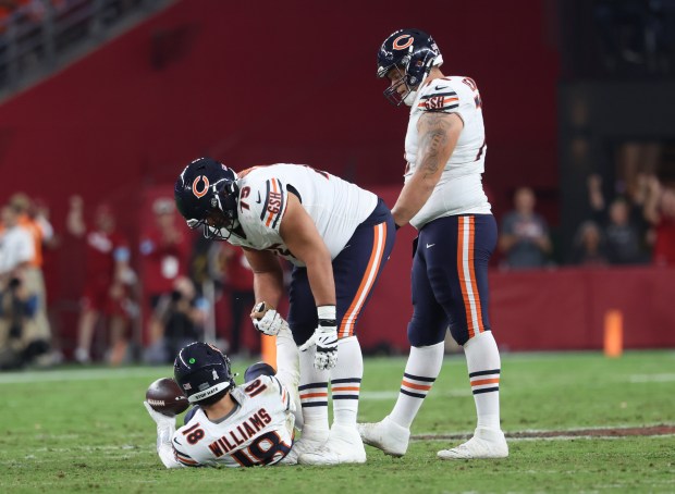 Bears quarterback Caleb Williams is picked up by offensive tackle Larry Borom after being sacked in the third quarter against the Cardinals at State Farm Stadium on Nov. 3, 2024, in Glendale, Ariz. (Stacey Wescott / Chicago Tribune)